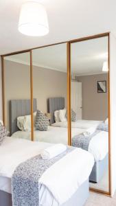 een kamer met 3 bedden en een spiegel bij Airth House in Airth