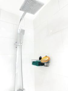 a shower with a light on a white wall at Cwtch Corner By MGroup SA in Treherbert