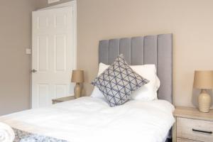a bedroom with a white bed with a gray headboard at Airth House in Airth