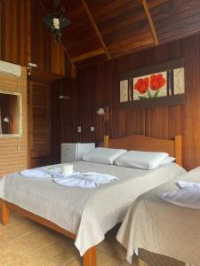 um quarto com duas camas e um quadro na parede em Pousada Serras De Monte Verde em Monte Verde