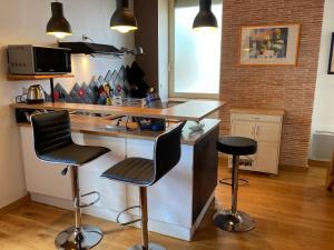 kuchnia z blatem i 2 stołkami barowymi w obiekcie charmant appartement centre ville w mieście Millau