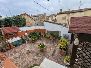 an outdoor courtyard with potted plants and a building at B&B A Casa di Mael in San Costanzo