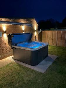 una bañera de hidromasaje sentada en un patio por la noche en Bromstone House, Broadstairs en Broadstairs