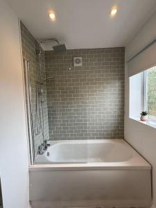 baño con bañera blanca y ventana en Bromstone House, Broadstairs en Broadstairs