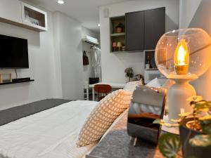 een slaapkamer met een bed en een tafel met een lamp bij Primo Condo Studio Type - One Pontefino Tower in Batangas City