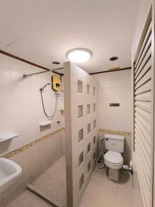 y baño con ducha, aseo y lavamanos. en La Casa South Pattaya Hotel en Pattaya South