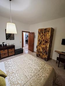 a bedroom with a bed and a dresser and a table at B&B A Casa di Mael in San Costanzo