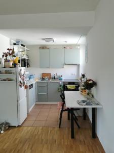 eine Küche mit weißen Schränken und einem Tisch mit Blumen darauf in der Unterkunft Center Schwabing Spacious flat in München