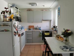 eine Küche mit einem weißen Kühlschrank und einem Tisch in der Unterkunft Center Schwabing Spacious flat in München