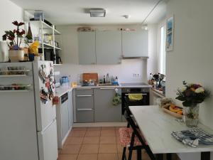 a kitchen with a white refrigerator and a table at Center Schwabing Spacious flat in Munich