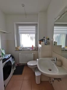 een badkamer met een witte wastafel en een toilet bij Center Schwabing Spacious flat in München
