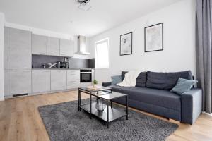 a living room with a blue couch and a table at Moderne Apartments im Herzen von Osnabrück I private Tiefgarage I home2share in Osnabrück