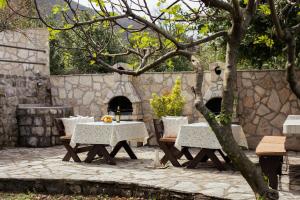 a patio with two tables and a stone wall at Step to Kotor bay St-oliv in Kotor