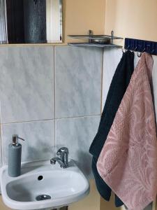 W łazience znajduje się umywalka i różowy ręcznik. w obiekcie Viesu nams RŪĶĪŠI w mieście Rugāji