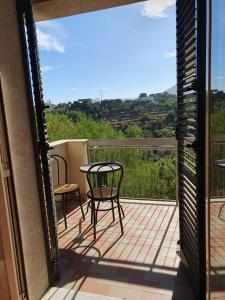 een patio met een tafel en stoelen op een balkon bij Nika Holiday Home in Casteldaccia