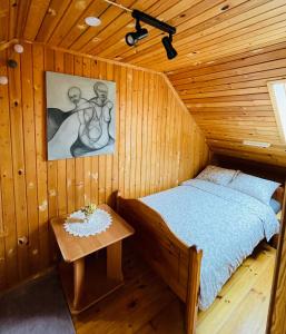 a bedroom with a bed in a wooden room at Viesu nams RŪĶĪŠI in Rugāji