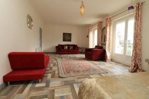 een woonkamer met een rode stoel en een bank bij L'Alhambra - Gîte Haut de Gamme in Vierzon