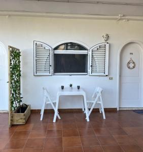 マスパロマスにあるLovely apartment Taidiaの窓付きの客室で、白いテーブルと椅子が備わります。