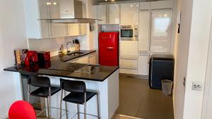 eine Küche mit einem roten Kühlschrank und weißen Schränken in der Unterkunft US embassy spacious apartment nine elms in London