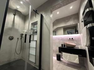 a bathroom with a glass shower and a sink at Lorenzo x Casa Norte in Birgu
