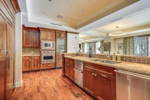 a large kitchen with wooden cabinets and stainless steel appliances at Ski-InandSki-Out Condo in Park City with 6 Balconies! in Park City