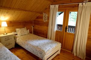 a bedroom with a bed and a window in a cabin at Leśniczówka Białogóra in Białogóra