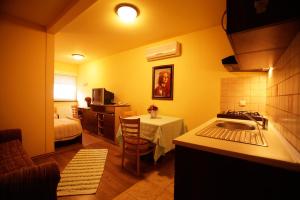 a room with a kitchen and a bedroom with a bed at Tribunia Beach Hotel in Tribunj