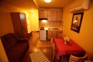 ein Wohnzimmer mit einem Tisch und einer Küche in der Unterkunft Tribunia Beach Hotel in Tribunj