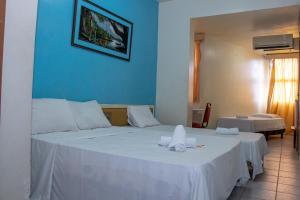 um quarto de hotel com duas camas com lençóis brancos em Prestige Manaus Hotel em Manaus