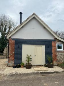 een blauw-wit huis met een garage bij The Old Dairy in Newbury