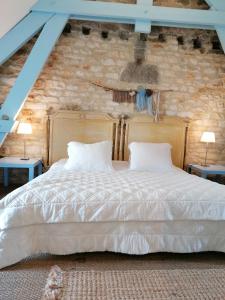 1 dormitorio con 1 cama blanca grande y 2 lámparas en La Malposte en Reviers