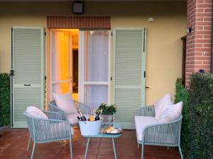 eine Terrasse mit Stühlen, einem Tisch und einer Tür in der Unterkunft Dimore - Granaio nr 5 Appartamento di charme con giardino privato in campagna in Asti
