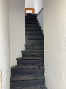 a stairway with grey carpeted stairs in a house at NaturPur in Monschau