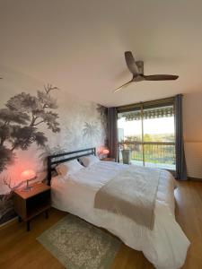 - une chambre avec un lit et un ventilateur de plafond dans l'établissement Horizon sur le Cher, à Montrichard