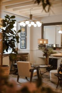 une salle à manger avec une table, des chaises et un lustre dans l'établissement Hotel Pulitzer Paris, à Paris