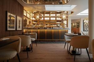 restauracja ze stołami i krzesłami oraz bar w obiekcie Hotel Pulitzer Paris w Paryżu