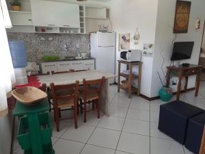 a kitchen with a table and chairs and a refrigerator at Village Acapulco - Itacimirim/BA in Itacimirim