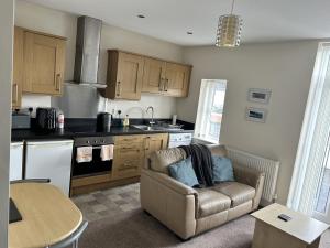 a living room with a couch and a kitchen at Norton Serviced Apartments in Stockton-on-Tees