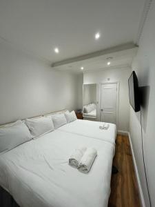 a bedroom with a white bed with towels on it at Lamont Hotel in London