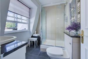 ein Bad mit einer Dusche, einem WC und einem Waschbecken in der Unterkunft Lamont Hotel in London