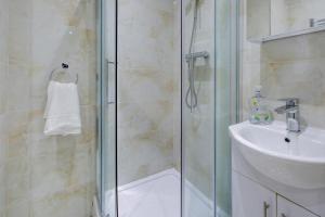 ein Bad mit einer Dusche und einem Waschbecken in der Unterkunft Lamont Hotel in London