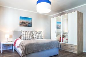 Schlafzimmer mit einem Bett und einem Spiegel in der Unterkunft RELOC Serviced Apartments Zurich-Oerlikon in Zürich