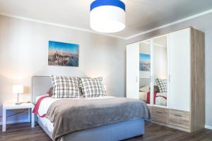 a bedroom with a bed and a mirror at RELOC Serviced Apartments Zurich-Oerlikon in Zürich