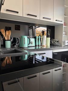 a kitchen with a black counter top with appliances at Apartament Teresa in Nysa