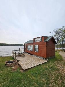 a small house on a dock next to a lake at Wheeler Lake Riverbend Haven 2 in Stilwell