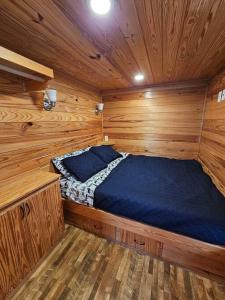 a bed in a wooden room in a cabin at Wheeler Lake Riverbend Haven 2 in Stilwell