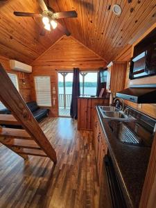 a kitchen with wooden floors and a ceiling fan at Wheeler Lake Riverbend Haven 2 in Stilwell