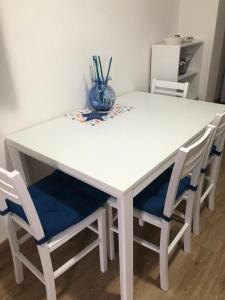 un tavolo bianco con due sedie e un vaso sopra di Casa 3 pesciolini a Portoferraio
