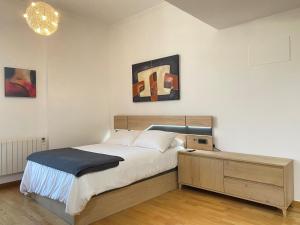 Un dormitorio con una cama y dos cuadros en la pared. en PUERTA DEL SOL - Vigo Centro, en Vigo