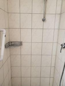 y baño con ducha y pared de azulejos blancos. en 3: Einfache 1-Zimmer Wohnung in Bad Wörishofen en Bad Wörishofen